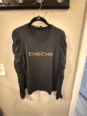 bebe Black Long-Sleeve Top with Gold Logo and Ruched Sleeves